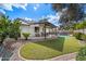 Expansive backyard boasts a covered patio, lush lawn, desert landscaping, and a refreshing pool, perfect for outdoor living at 1002 E Grandview Rd, Phoenix, AZ 85022