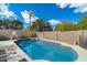Sparkling blue pool with basketball hoop is surrounded by lush greenery and a block wall fence for privacy at 1002 E Grandview Rd, Phoenix, AZ 85022