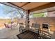 Covered patio with comfortable seating, dining area, and outdoor grill at 10356 E Meandering Trail Ln, Gold Canyon, AZ 85118
