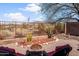 Charming backyard featuring a cozy fire pit area, desert landscaping, and open views of the surrounding landscape at 10356 E Meandering Trail Ln, Gold Canyon, AZ 85118