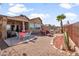 Spacious backyard features a covered patio, outdoor seating, desert landscaping, and a charming water feature at 10356 E Meandering Trail Ln, Gold Canyon, AZ 85118