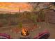 Inviting backyard with fire pit, seating area, desert landscaping, and mountain views at sunset at 10356 E Meandering Trail Ln, Gold Canyon, AZ 85118