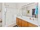 Bathroom featuring double sinks with wood cabinets, a glass-enclosed shower, and a large mirror at 10356 E Meandering Trail Ln, Gold Canyon, AZ 85118