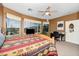 Bedroom featuring a wooden bed frame, ceiling fan, large windows with views, and workspace at 10356 E Meandering Trail Ln, Gold Canyon, AZ 85118