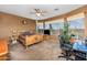 Bright bedroom featuring a rustic wood bed frame, ceiling fan, and an office space with a view at 10356 E Meandering Trail Ln, Gold Canyon, AZ 85118