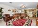 Open living room with a leather sectional, ceiling fan, and a view of the adjacent kitchen at 10356 E Meandering Trail Ln, Gold Canyon, AZ 85118