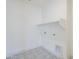 Functional laundry room with tile flooring and built in shelving, creating a organized space at 12698 N 153Rd Ave, Surprise, AZ 85379