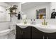 Well-lit bathroom with dual sinks, dark cabinets, gold fixtures, and a large mirror at 13614 N 38Th Pl, Phoenix, AZ 85032