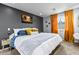 Comfortable bedroom with large bed, neutral bedding, orange curtains and a palm tree picture at 13614 N 38Th Pl, Phoenix, AZ 85032