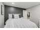 Charming bedroom featuring a black accent wall, a comfortable bed, and a door leading to another room at 13614 N 38Th Pl, Phoenix, AZ 85032