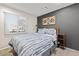 Comfortable bedroom with large window, gray accent wall, modern bed, stylish wall art and carpeted flooring at 13614 N 38Th Pl, Phoenix, AZ 85032