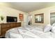 Cozy bedroom featuring a patterned comforter, a wooden dresser with a TV, and a mirror on the wall at 14145 N 92Nd St # 2077, Scottsdale, AZ 85260