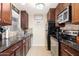 Galley kitchen with mosaic tile backsplash, dark countertops, and stainless steel appliances at 14145 N 92Nd St # 2077, Scottsdale, AZ 85260