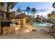A community pool area with a barbecue station, lounge chairs, and palm trees at 14145 N 92Nd St # 2077, Scottsdale, AZ 85260