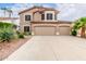 Inviting two-story home features a three-car garage, desert landscaping and a classic stucco facade at 1567 S Western Skies Dr, Gilbert, AZ 85296
