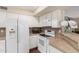Bright kitchen features white appliances and cabinets with a tan countertop and lovely wood floors at 1567 S Western Skies Dr, Gilbert, AZ 85296