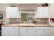 Kitchen sink featuring white cabinetry, stone backsplash, a large window, and granite countertops at 1567 S Western Skies Dr, Gilbert, AZ 85296
