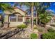 Close-up of the front of home, showing desert rock landscaping, with mature trees at 16446 N 59Th St, Scottsdale, AZ 85254