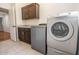 Functional laundry room features modern washer and dryer units, cabinet storage, and tiled floors at 16446 N 59Th St, Scottsdale, AZ 85254