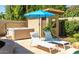 Backyard patio featuring lounge chairs with umbrella, hot tub, and pool house at 16446 N 59Th St, Scottsdale, AZ 85254