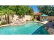 Serene pool area with rock features, lush landscaping, and an outdoor kitchen, perfect for entertaining at 16446 N 59Th St, Scottsdale, AZ 85254