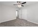 A bedroom featuring a ceiling fan, plush carpet, closet, and entry door at 19008 N Lousandra Dr, Maricopa, AZ 85138