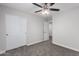 A bedroom with ceiling fan, plush carpet, closet, and entry door at 19008 N Lousandra Dr, Maricopa, AZ 85138