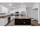 Kitchen with white cabinets, stainless steel appliances, granite countertops, and island with dark wood at 19008 N Lousandra Dr, Maricopa, AZ 85138