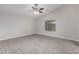 Large main bedroom features soft carpet, ceiling fan, and a large window for plenty of natural light at 19008 N Lousandra Dr, Maricopa, AZ 85138