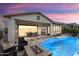 Inviting backyard featuring a pool, fire pit, covered patio, and desert landscape, creating a relaxing oasis at 20528 W Coolidge St, Buckeye, AZ 85396