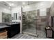 This bathroom features a frameless shower with gray tiling, built-in bench, and black cabinets at 20528 W Coolidge St, Buckeye, AZ 85396