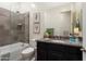 This bathroom features a shower over bath with glass frame and black vanity at 20528 W Coolidge St, Buckeye, AZ 85396