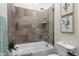 This bathroom features a tub with frameless glass frame, a shower head, and a small window at 20528 W Coolidge St, Buckeye, AZ 85396