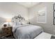 Bedroom featuring a large bed, a nightstand with a lamp, and a window with plantation shutters at 20528 W Coolidge St, Buckeye, AZ 85396