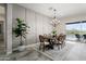 Dining area features stylish wainscoting, a modern chandelier, and views of the outdoor pool at 20528 W Coolidge St, Buckeye, AZ 85396