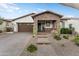 Charming home featuring a stone-accented porch and desert landscaping with a brick driveway at 20528 W Coolidge St, Buckeye, AZ 85396