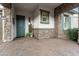 Covered front porch featuring stone columns and a brick-paved patio at 20528 W Coolidge St, Buckeye, AZ 85396