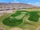 Scenic aerial view of the golf course with lush green grass, sand traps, and desert landscaping with mountain views at 20528 W Coolidge St, Buckeye, AZ 85396