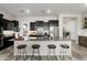 Modern kitchen with a granite island, black cabinetry, and stainless steel appliances at 20528 W Coolidge St, Buckeye, AZ 85396