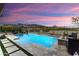 Outdoor pool and mountain view at sunset, with lounge chairs and patio at 20528 W Coolidge St, Buckeye, AZ 85396