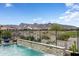 Backyard pool with rock waterfall feature, desert landscape, and mountain views, perfect for relaxation and enjoyment at 20528 W Coolidge St, Buckeye, AZ 85396
