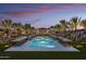 Stunning community pool area featuring multiple pools, lounge chairs, and palm trees against a sunset backdrop at 20528 W Coolidge St, Buckeye, AZ 85396