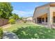 Backyard featuring grassy area, shrubbery, and block fence at 2068 S Sailors Ct, Gilbert, AZ 85295