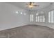 Spacious bedroom features carpet, large windows, and a ceiling fan at 2068 S Sailors Ct, Gilbert, AZ 85295