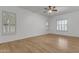 Bedroom featuring wood floors, ceiling fan, and shuttered windows at 2068 S Sailors Ct, Gilbert, AZ 85295