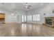 Open-concept living room with fireplace, white walls, brick floors, and natural light at 2068 S Sailors Ct, Gilbert, AZ 85295