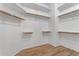 Bright walk-in closet features custom shelving and wood-look tile flooring at 2068 S Sailors Ct, Gilbert, AZ 85295