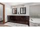 Bathroom with double sinks, dark wood cabinets, and tub at 2108 E Tecoma Rd, Phoenix, AZ 85048