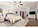 Spacious bedroom features wood floors, ceiling fan, and ensuite bath with sliding barn doors at 2108 E Tecoma Rd, Phoenix, AZ 85048