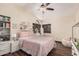 Comfortable bedroom with a ceiling fan, window with wooden blinds and light pink themed decor at 2108 E Tecoma Rd, Phoenix, AZ 85048